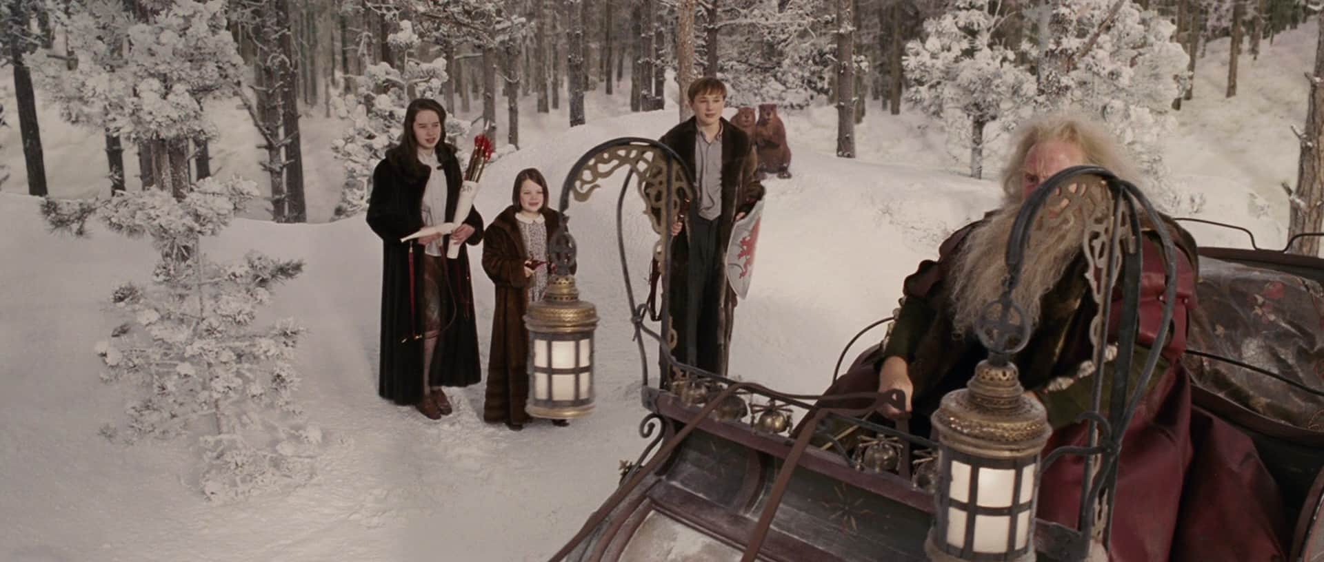  Children stand in a snowy forest near a man in a sleigh in this image from Walt Disney Pictures.