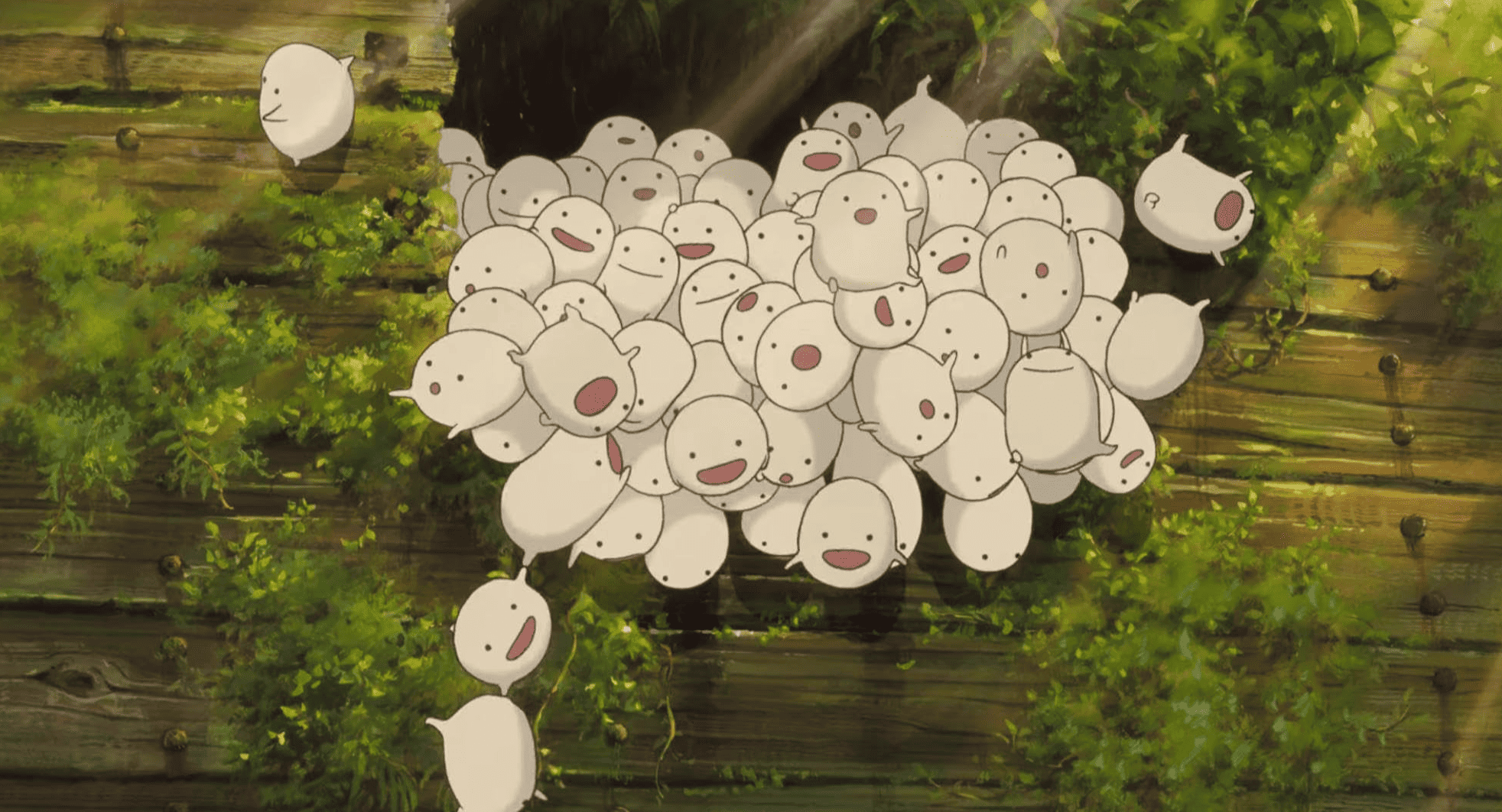 An animated group of small, round creatures exits through a hole in this image from Studio Ghibli. 