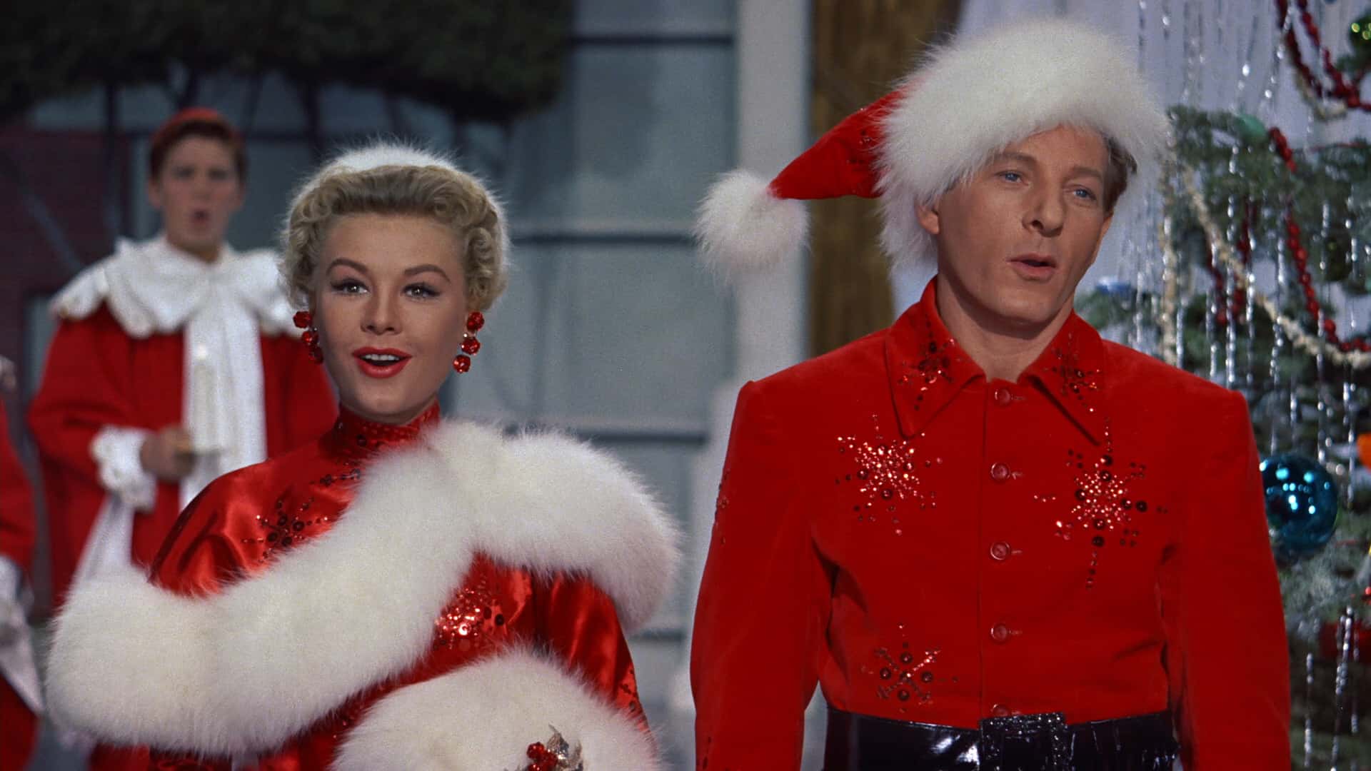 A woman and a man singing in Christmas outfits in this image from Paramount Pictures.