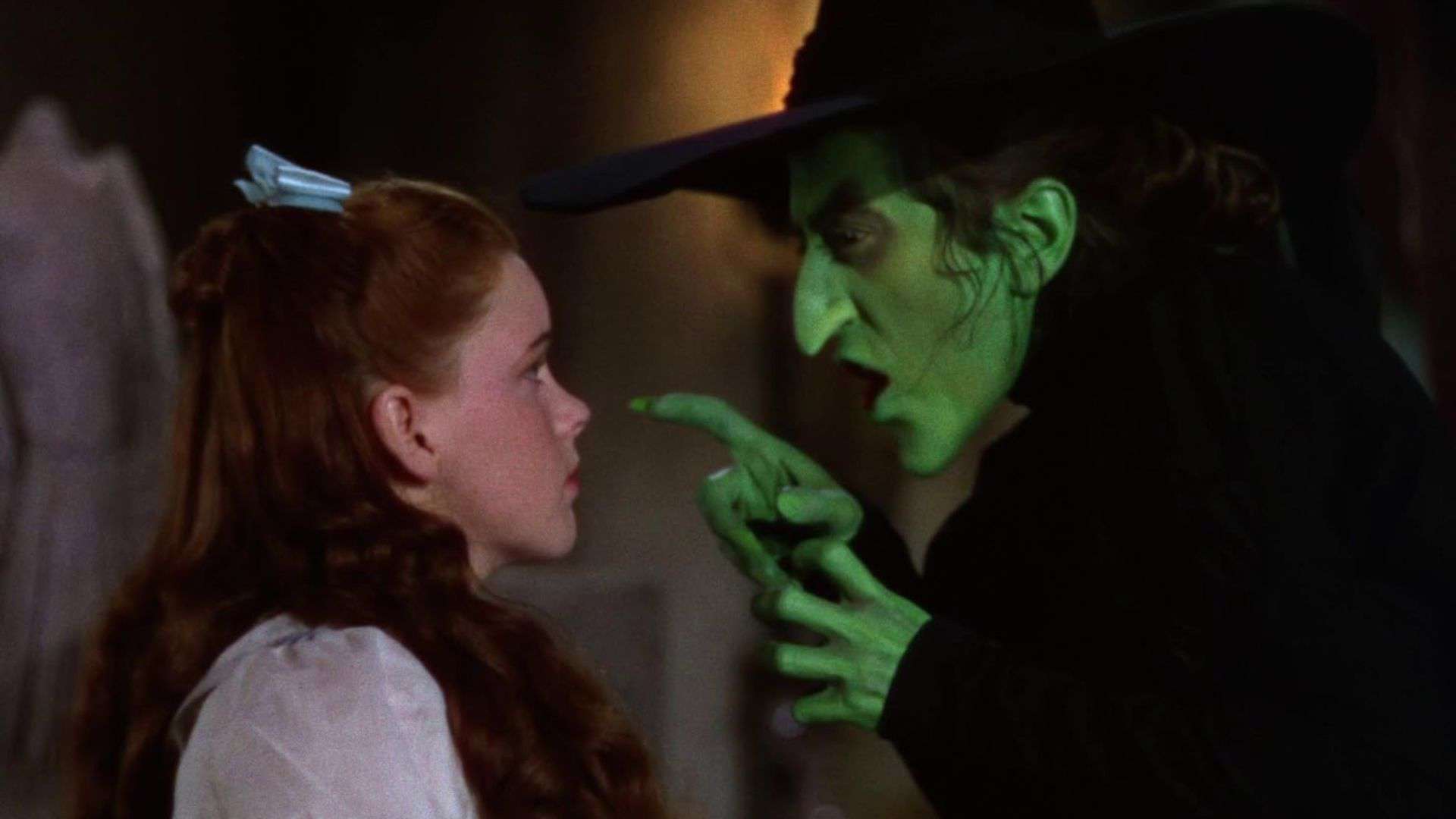 A wicked green witch threatens a young girl in this image from Metro-Goldwyn-Mayer.