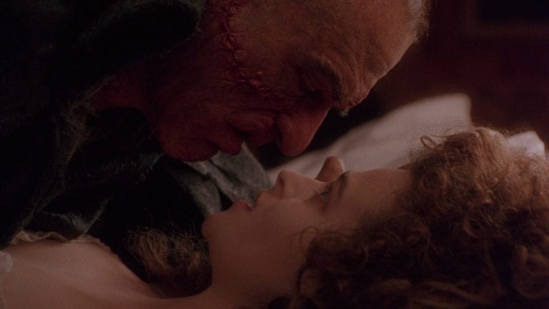 A disfigured man wakes a woman at close quarters in this image from TriStar Pictures.