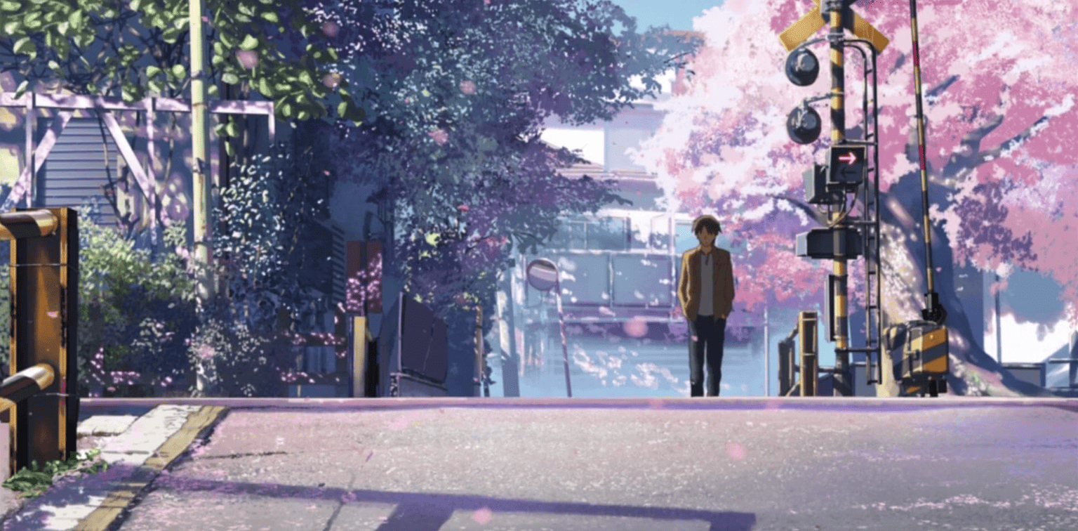 A boy walks along a street surrounded by cherry blossom trees in this image from CoMix Wave Films.