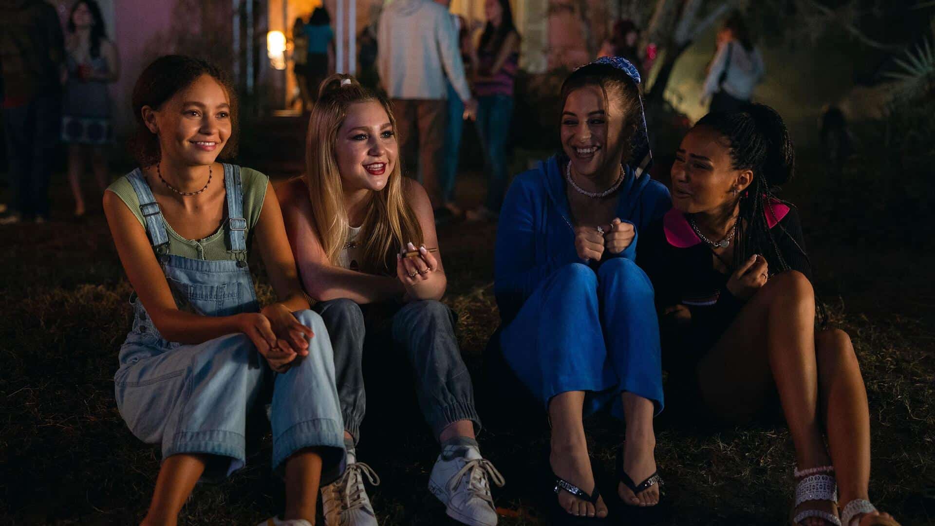 Four teenage girls sitting on a front lawn in this photo from Freestyle Picture Company.