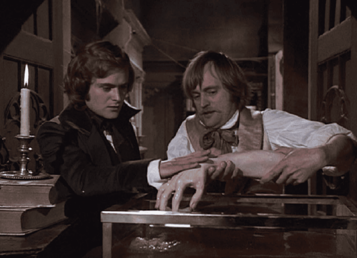 Two men examine a detached hand and forearm in this image from Universal Television.