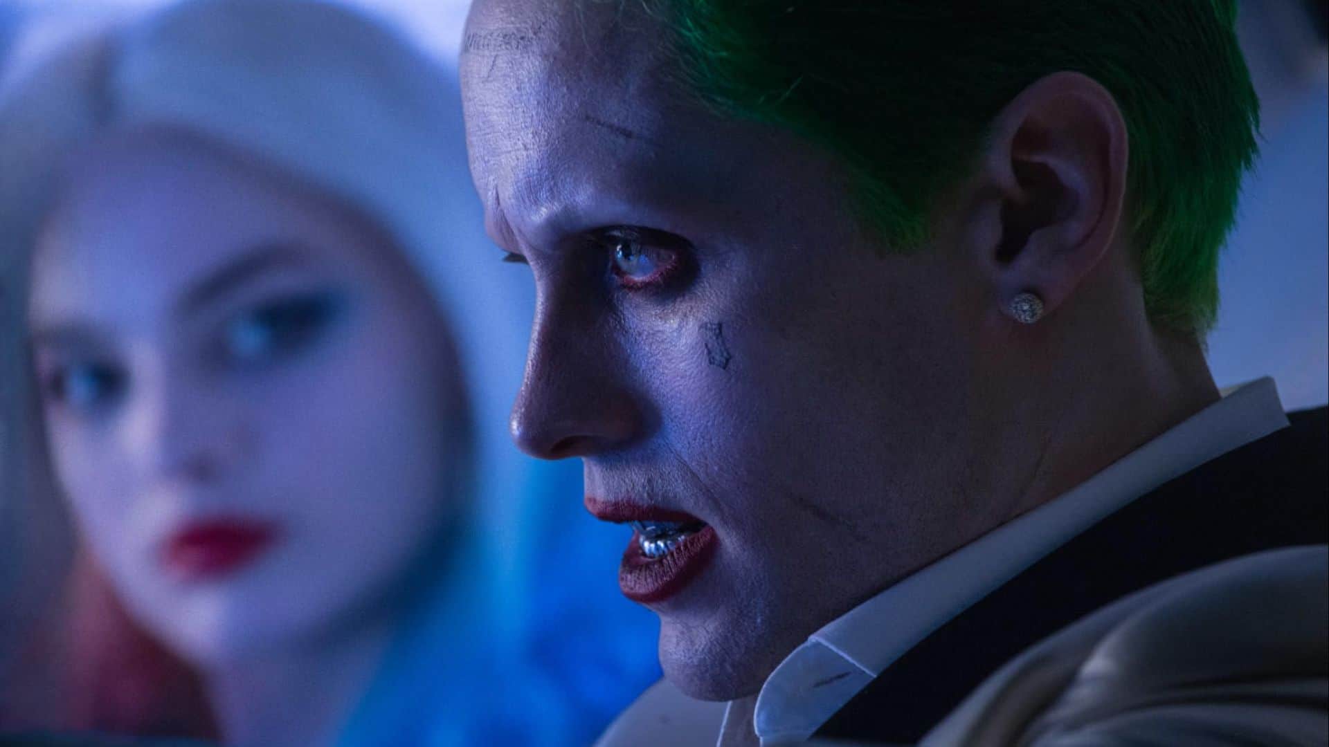 A blonde woman looks at a man with green hair and face tattoos in this image from Atlas Entertainment.