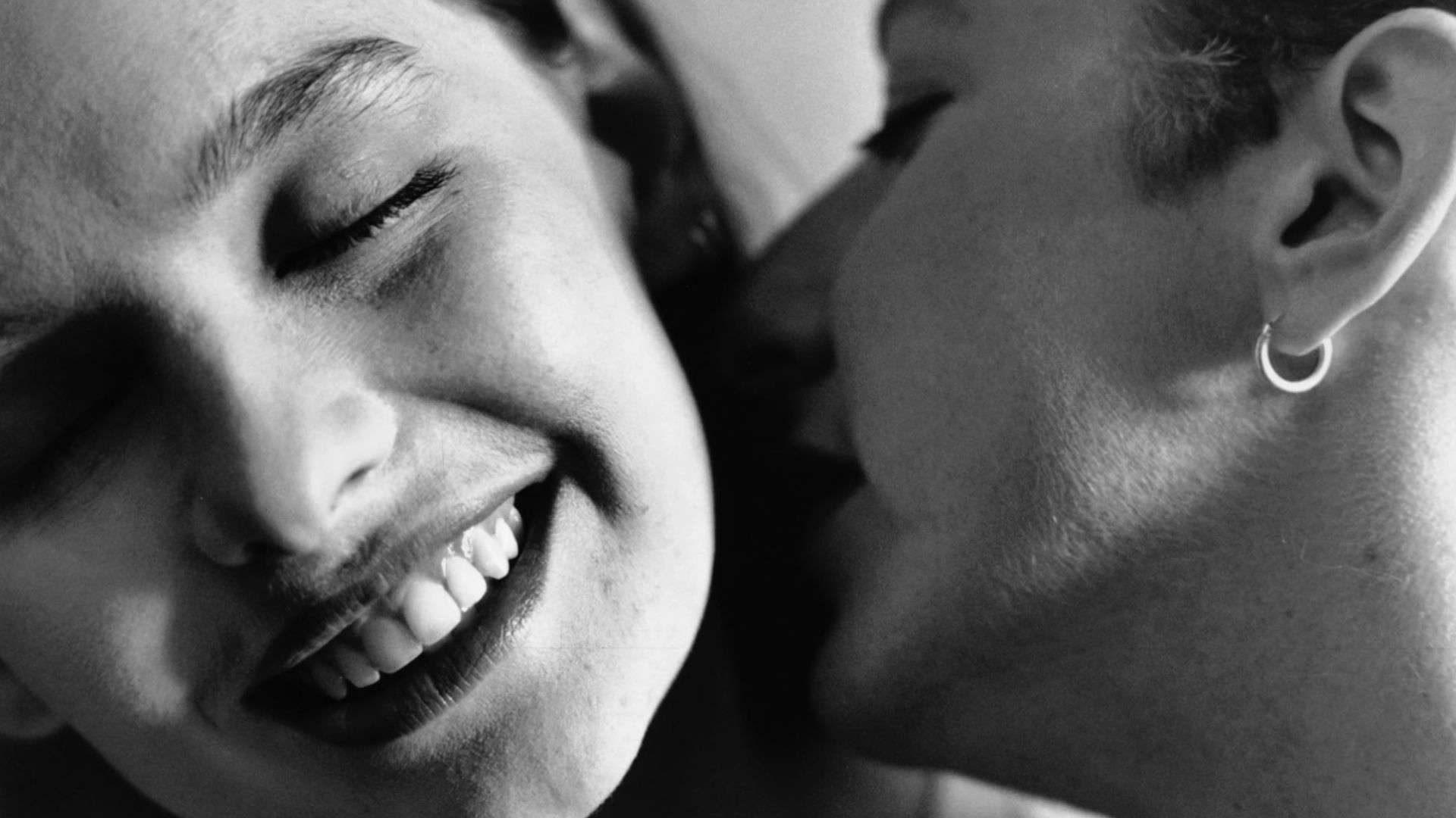 A close-up black and white photo of a woman kissing another woman’s neck in this image from The Samuel Goldwyn Company.