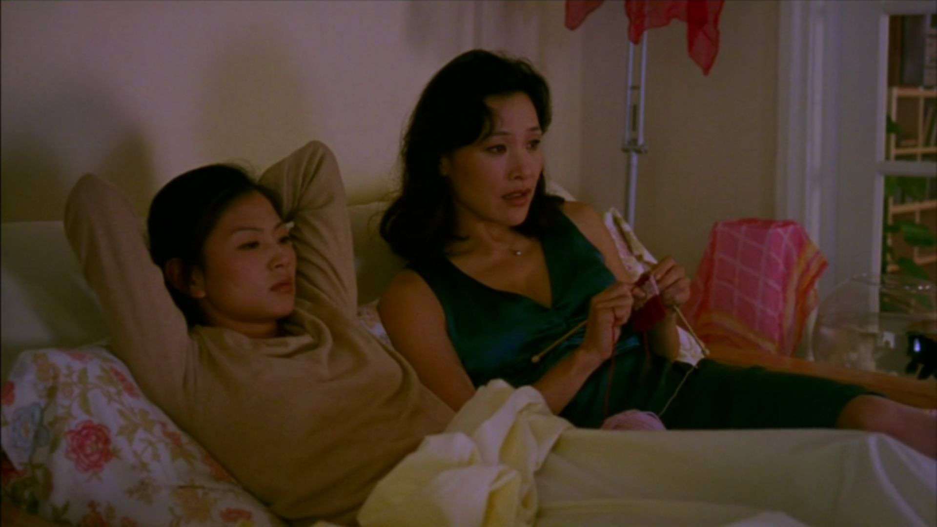 A woman knits in bed next to another woman in this image from Destination Films.