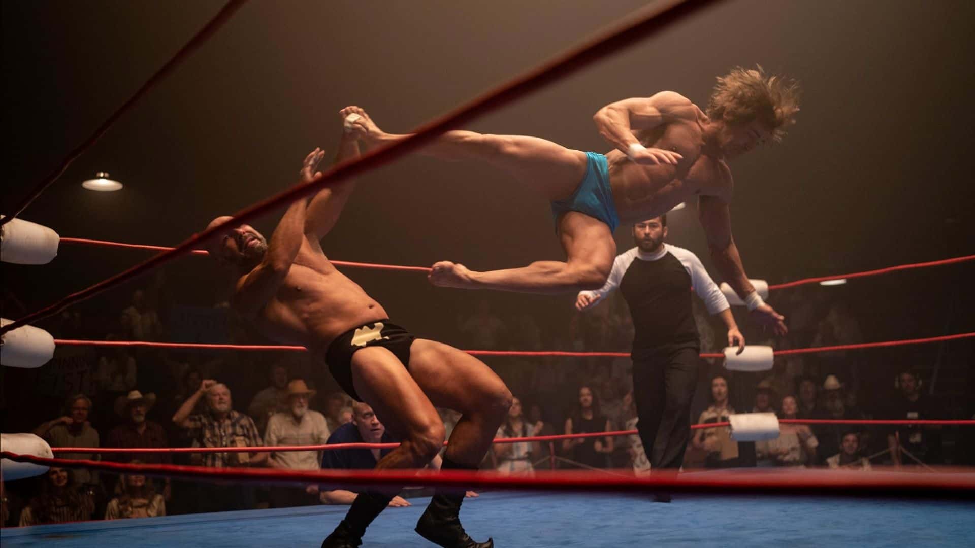 A wrestler does a flying kick into another wrestler in this image from A24.