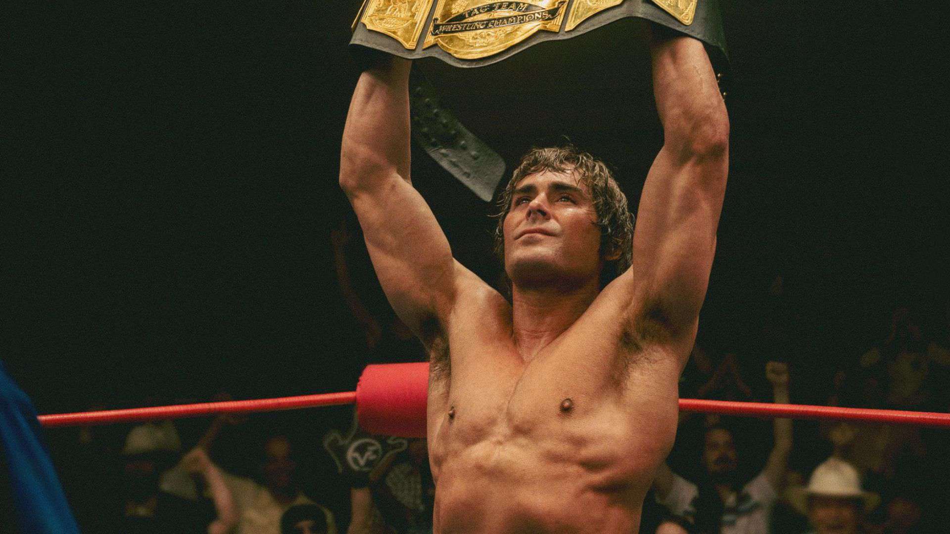 A wrestler holds up a belt for Tag Team Wrestling Champions in this image from A24.