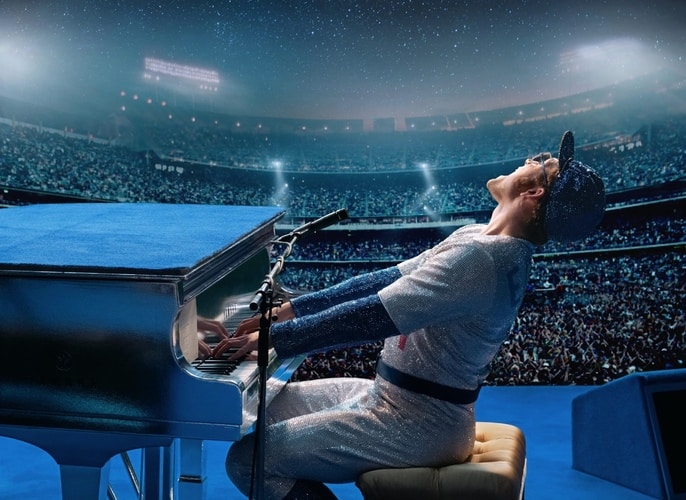 A man in a baseball uniform plays a piano on stage at a stadium in this image from New Republic Pictures.