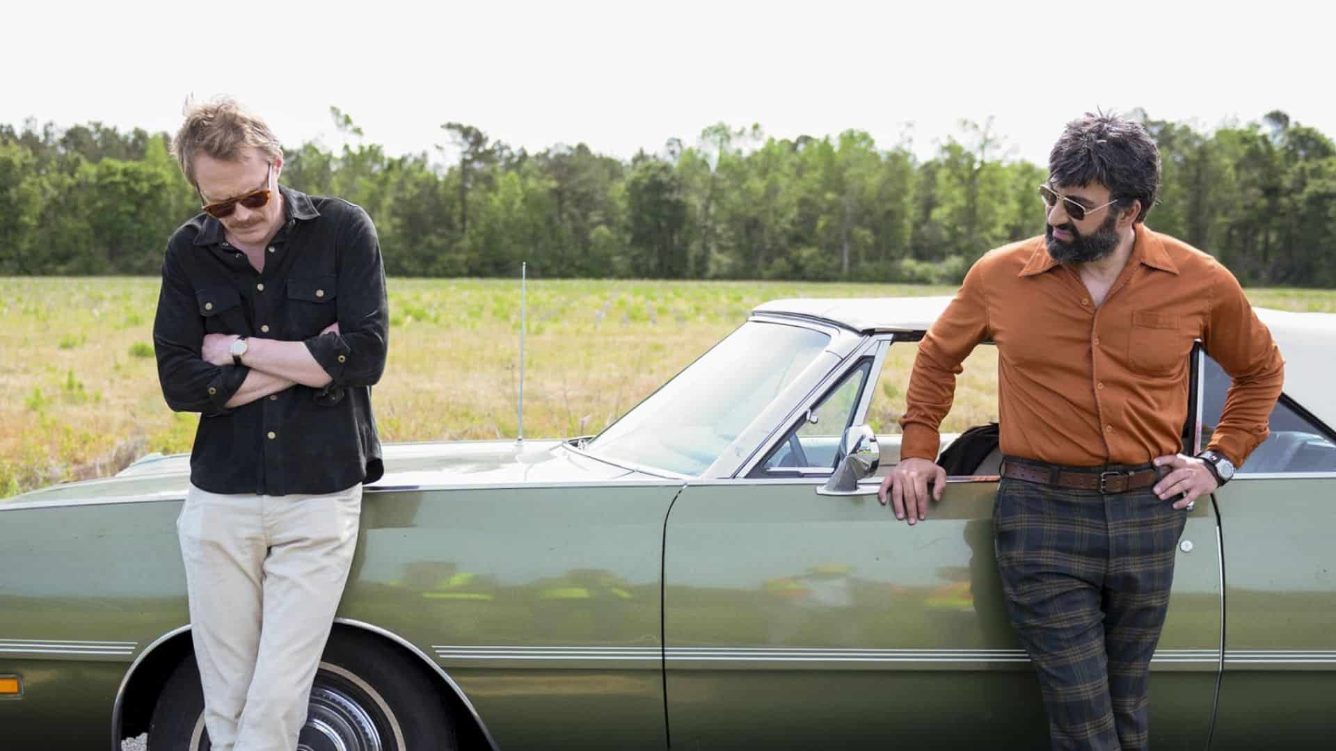 Two men lean on a green car in this image from Amazon Studios.