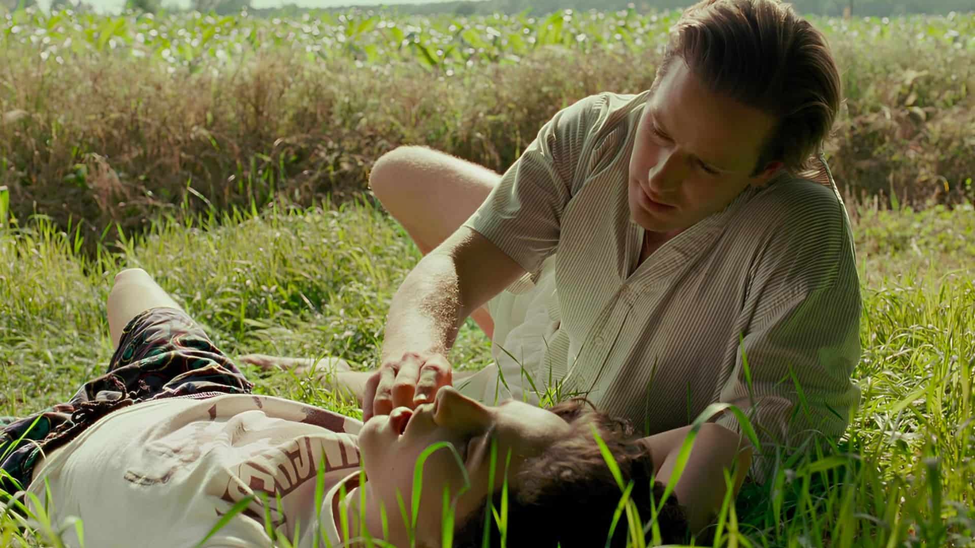 Two men lie next to each other in a grassy field in this image from Frenesy Film Company.