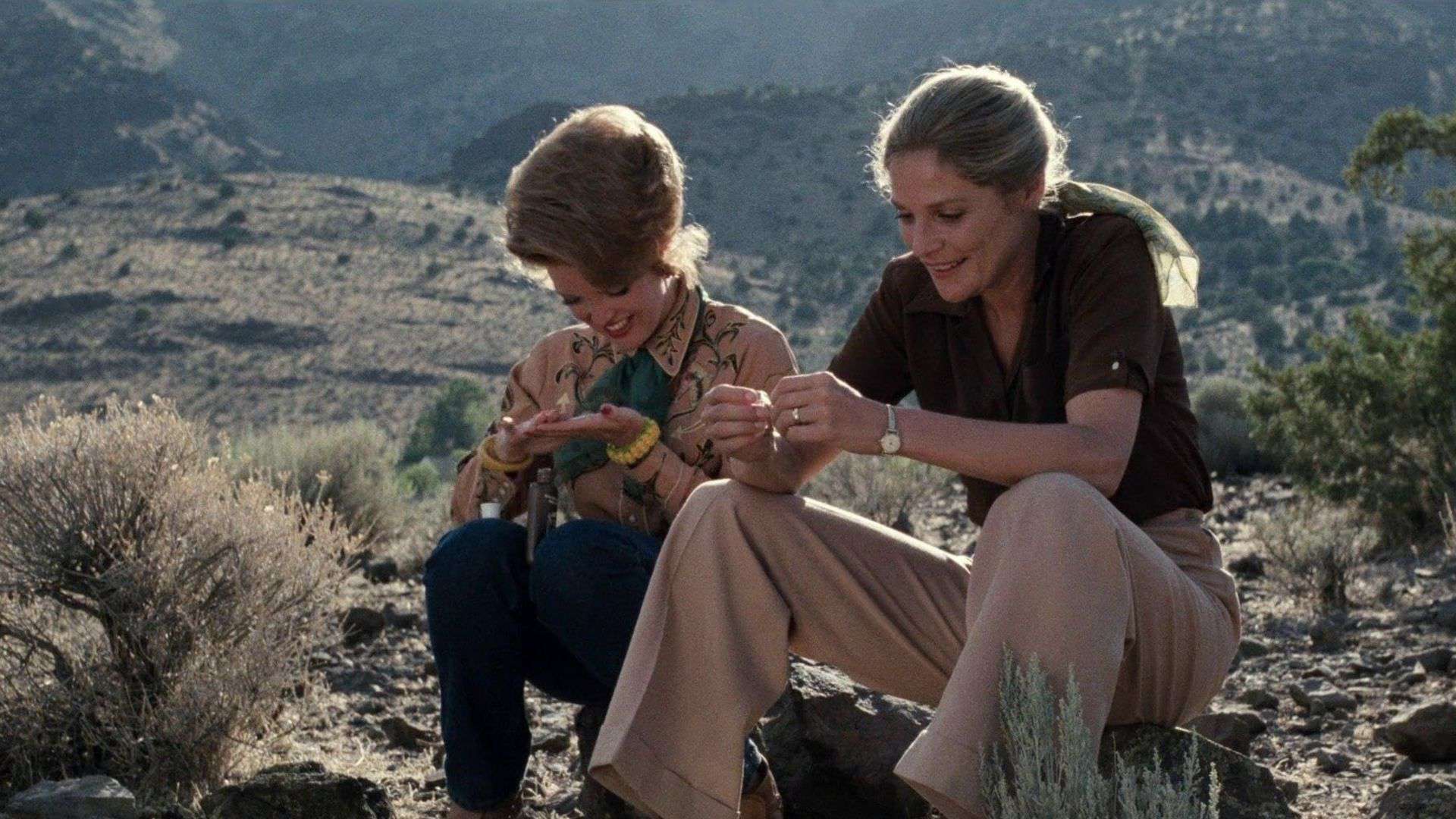 Two women sitting in a desert landscape in this image from Desert Hearts Productions.
