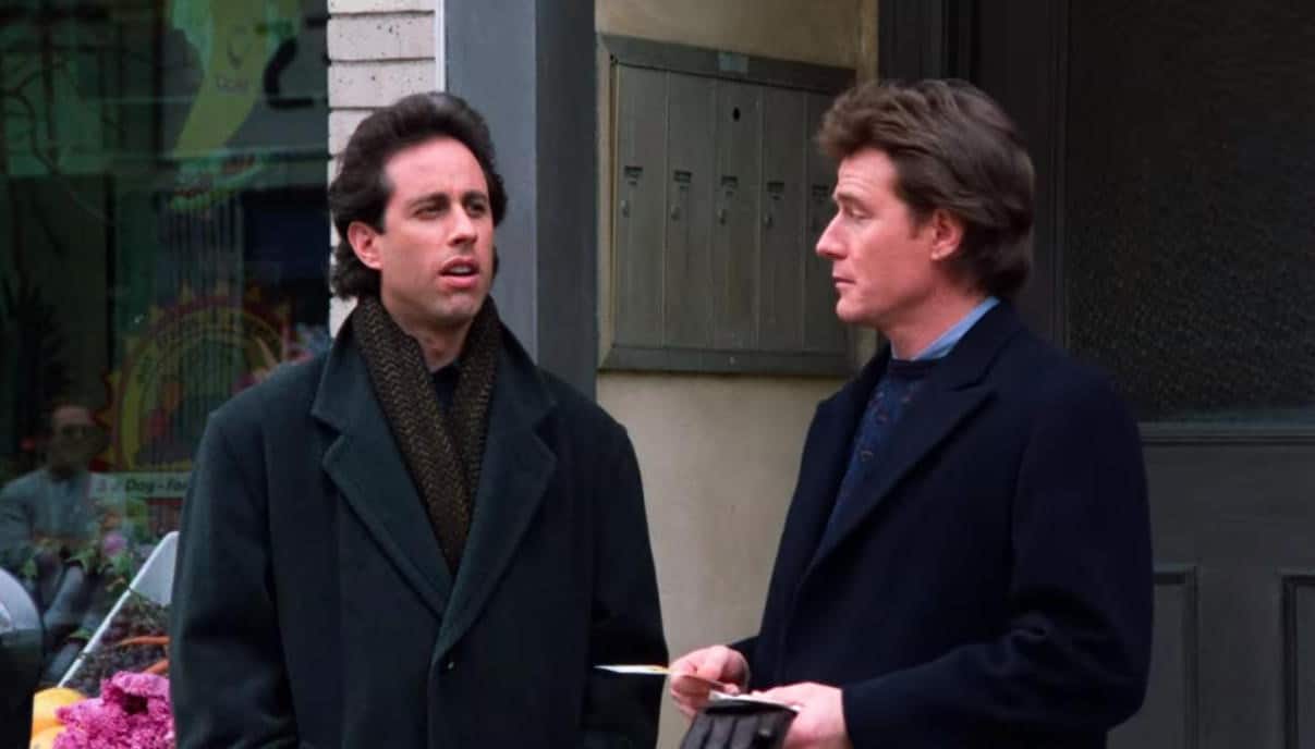 A pair of men exchange tickets on the sidewalk in this image from West-Shapiro Productions.