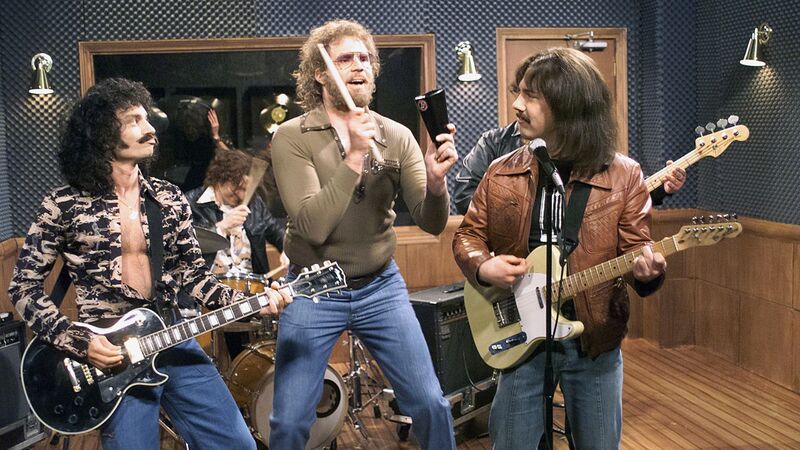 A band performs in a recording studio with guitars, drums, and a cowbell in this image from NBC Studios.