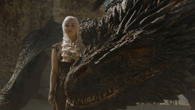 A large dragon places its head next to a blonde woman in this image from HBO Entertainment.