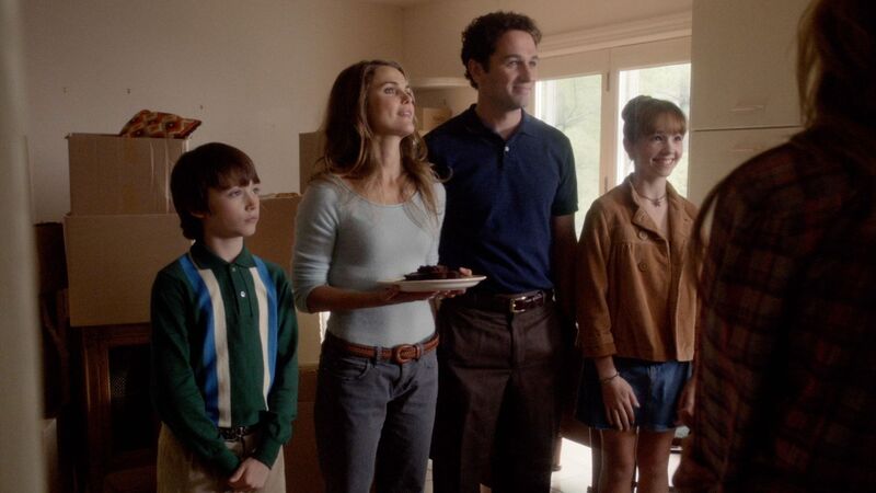 A mother and father with their two children talk to new neighbors in this image from Amblin Television.