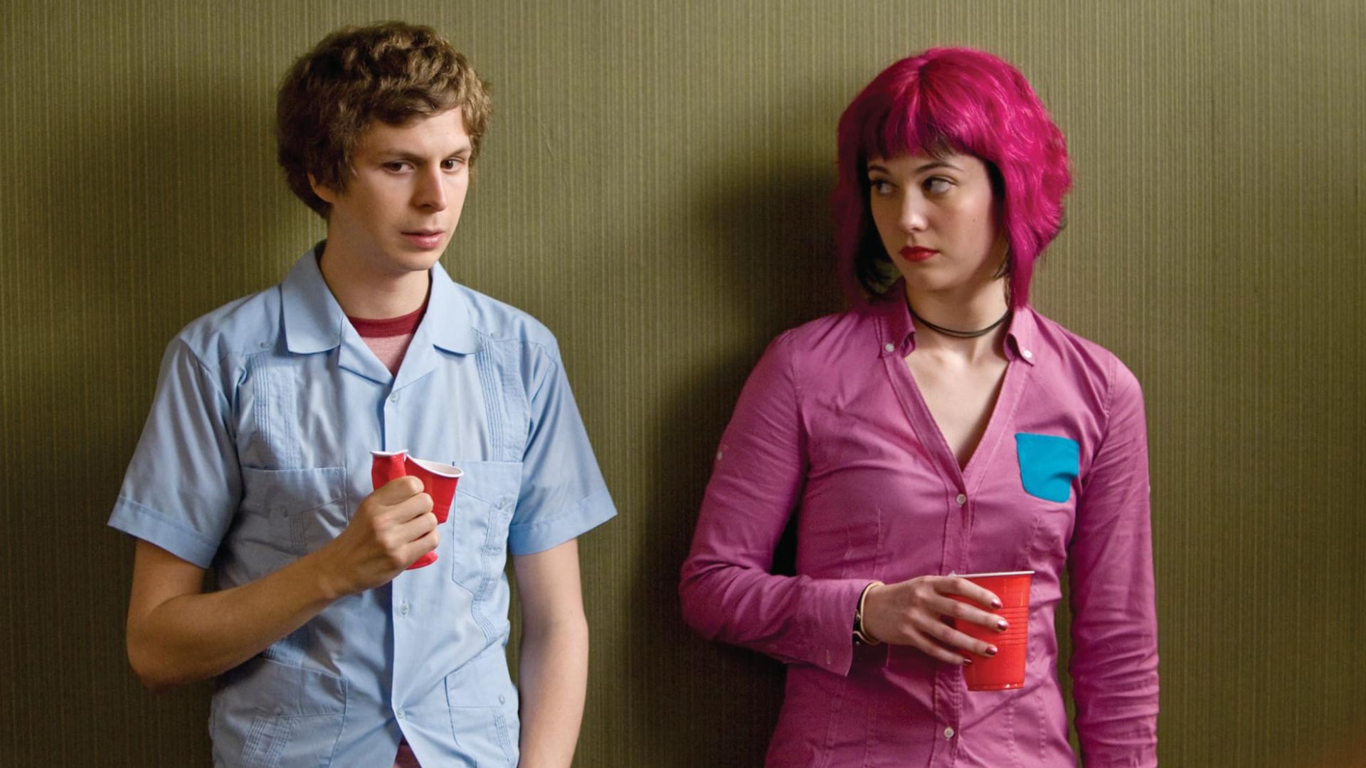 A young man and woman lean against a wall holding red party cups in this image from Universal Pictures.