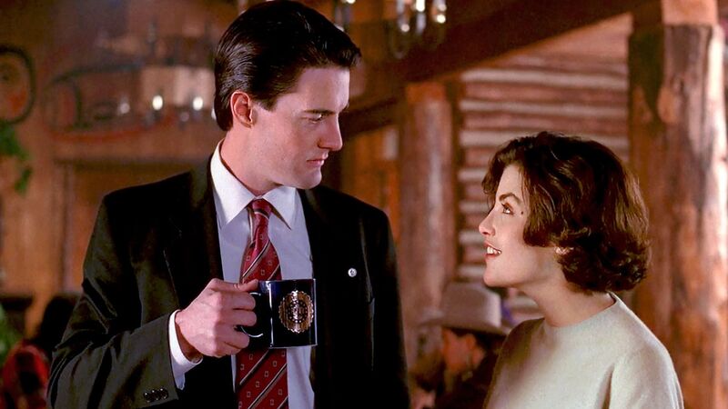 An FBI agent holding a mug looks at a young woman with brown hair in this image from Lynch/Frost Productions.
