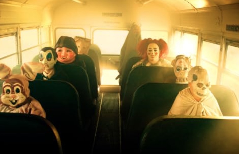 A group of costumed children rides a school bus in this image from Warner Premiere.