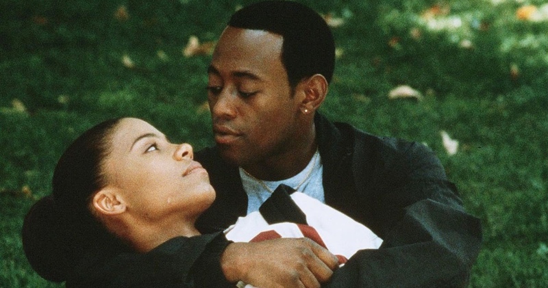 A young couple embraces while lying in the grass in this image from 40 Acres and a Mule Filmworks.