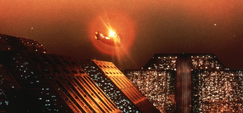A hovercar flies over pyramid-like buildings in this image from The Ladd Company.