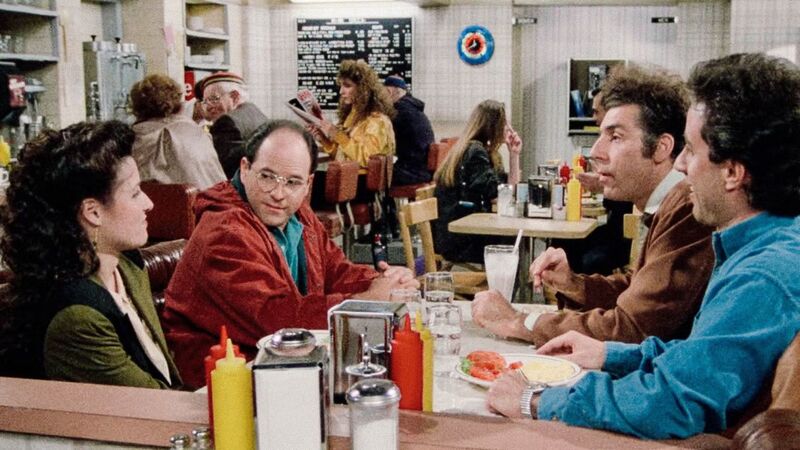 Four friends sit in a diner booth in this image from West/Shapiro Productions.
