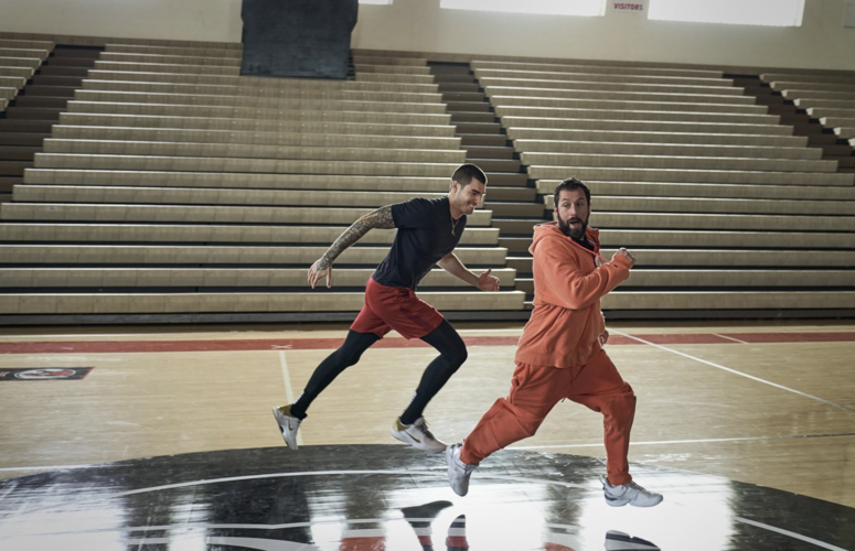  A basketball athlete playfully chases his coach on the court in this image from Happy Madison Productions.