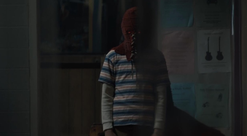 A boy with glowing eyes stands with a hooded cape covering his face in this image from Screen Gems.