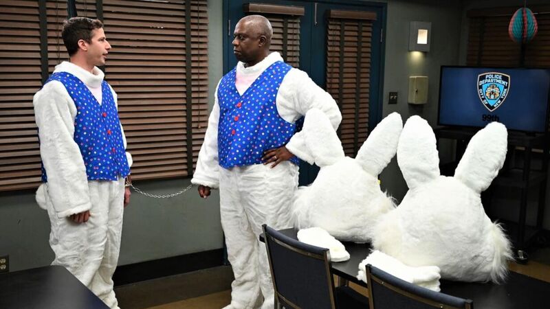 Two men handcuffed to each other wearing Easter Bunny suits stand in a police department in this image from Fremluon.