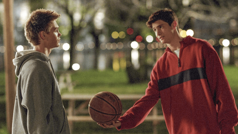 A teen hands a basketball to another teen in this image from Tollin/Robbins Productions.
