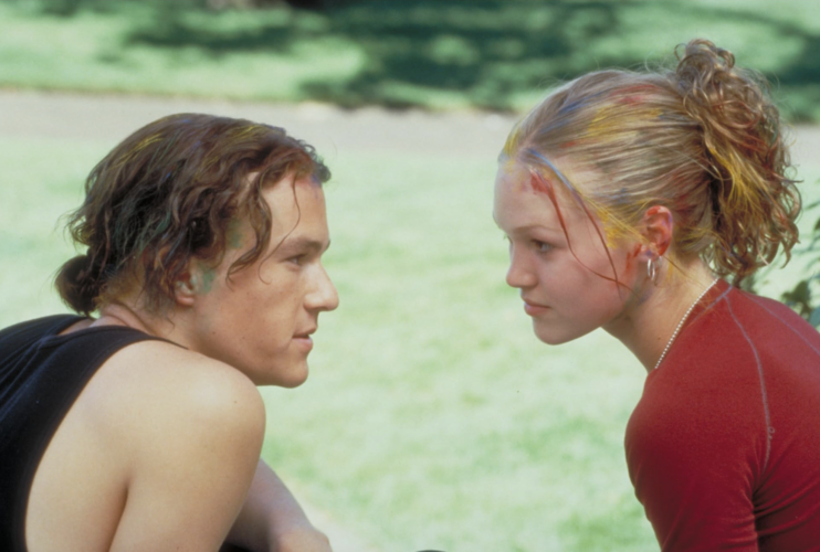 A young couple with paint streaks in their hair sits in a park in this image from Touchstone Pictures.