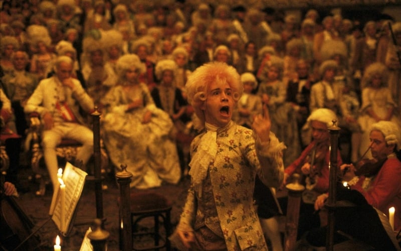 An eccentric conductor enthusiastically leads an orchestra in this photo from The Saul Zaentz Company.
