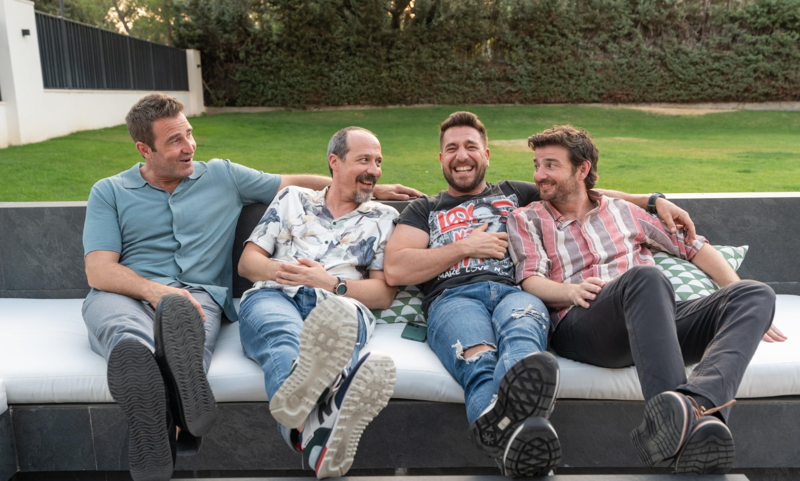 Un grupo de hombres sentados en un sofá riéndose en esta imagen de Contubernio Films.