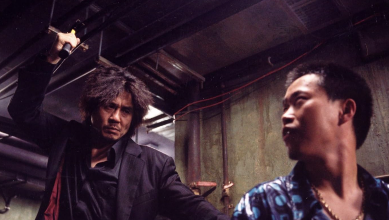 A tense scene with two men, one holding a hammer above his head and the other facing him with a wary expression in this image from Egg Film.