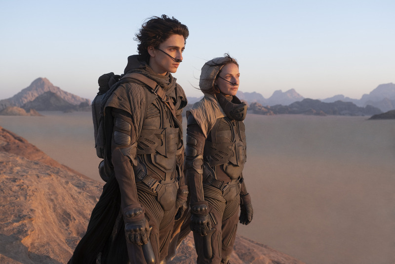 A man and a woman in space gear look out on a lake in this image from Legendary Pictures.