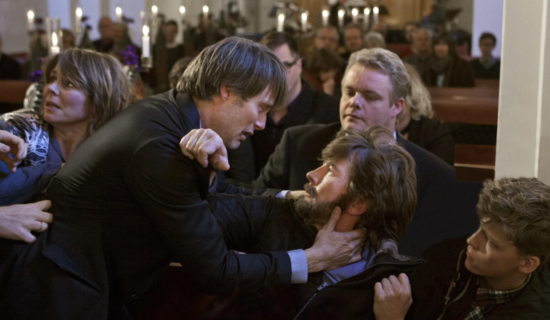 Two men are in a physical altercation in a church while others try to intervene in this image from Zentropa Entertainment.