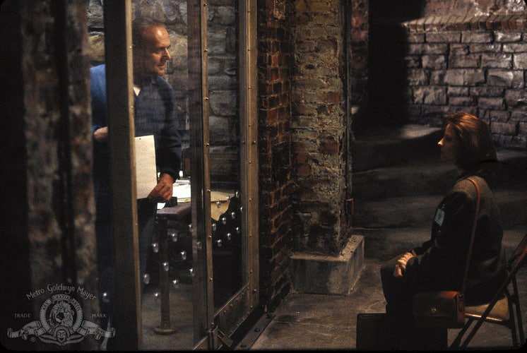 A man talks to a woman through a glass-paneled cell in this photo from Strong Heart/Demme Production.