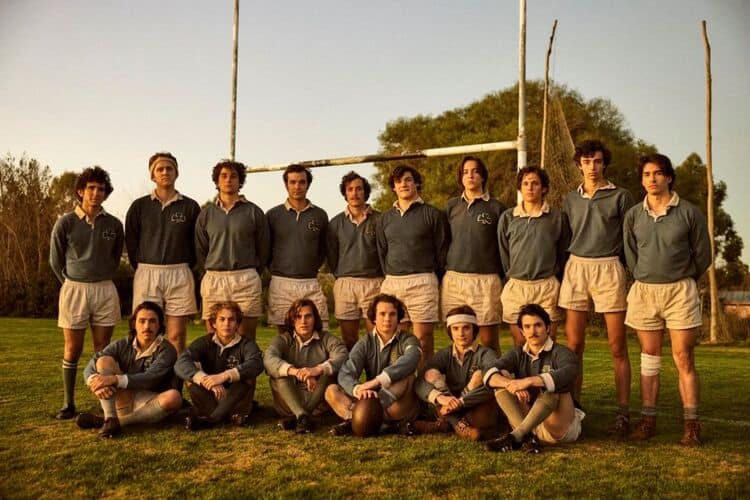 A group of uniformed men on a sports team pose for a picture on a rugby field in this photo by Misión de Audaces Films.