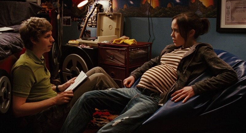 A teen couple sits on a bedroom floor reading in this photo from Mandate Pictures.
