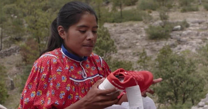A woman looks at a shoe in this image from No Ficción.