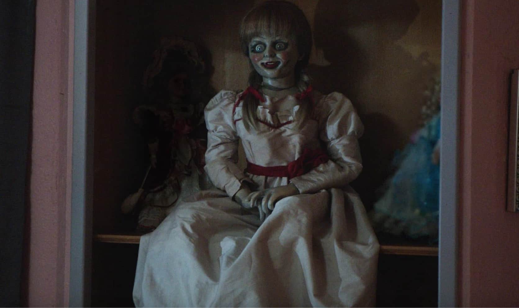 A creepy doll in a dress sits in the closet in this image from Warner Bros. Pictures.