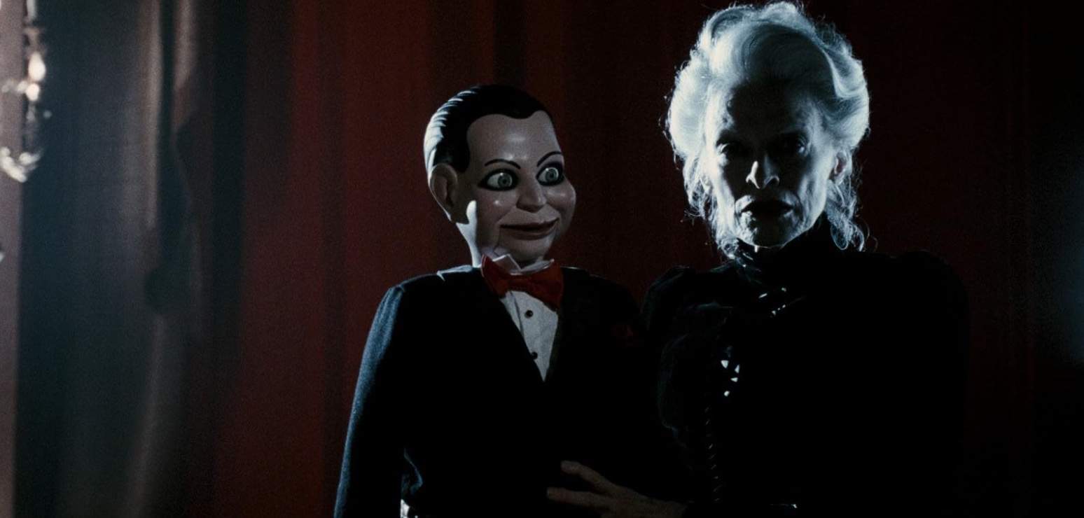 An old woman holds a ventriloquist doll in this image from Twisted Pictures.