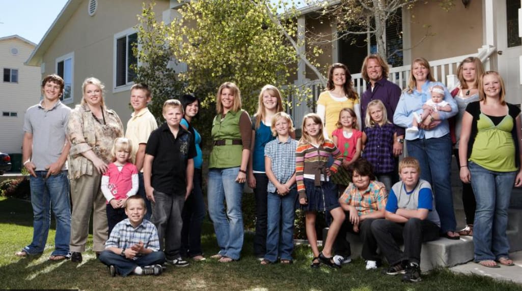 A large family poses in front of a house in this image from Figure 8 Films.