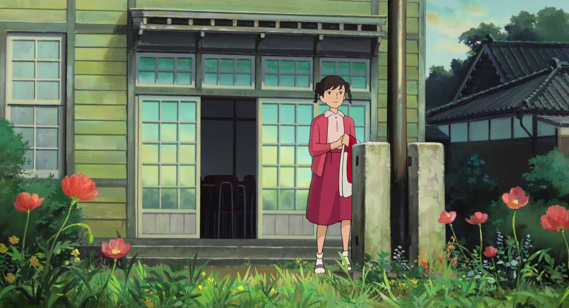 An animated girl standing next to a flagpole in this image from Studio Ghibli.