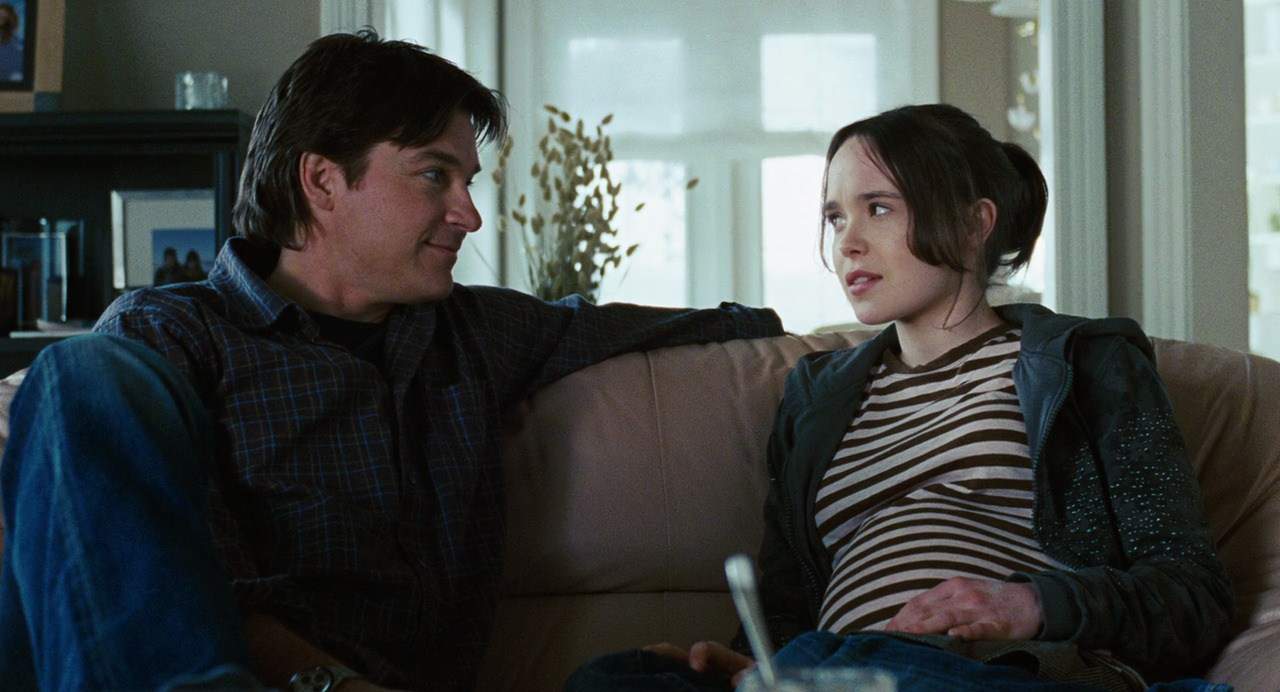 A man and a pregnant girl talk on a couch in this image from Fox Searchlight Pictures.